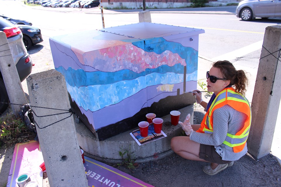 Artist painting green electrical box downtown sudbury